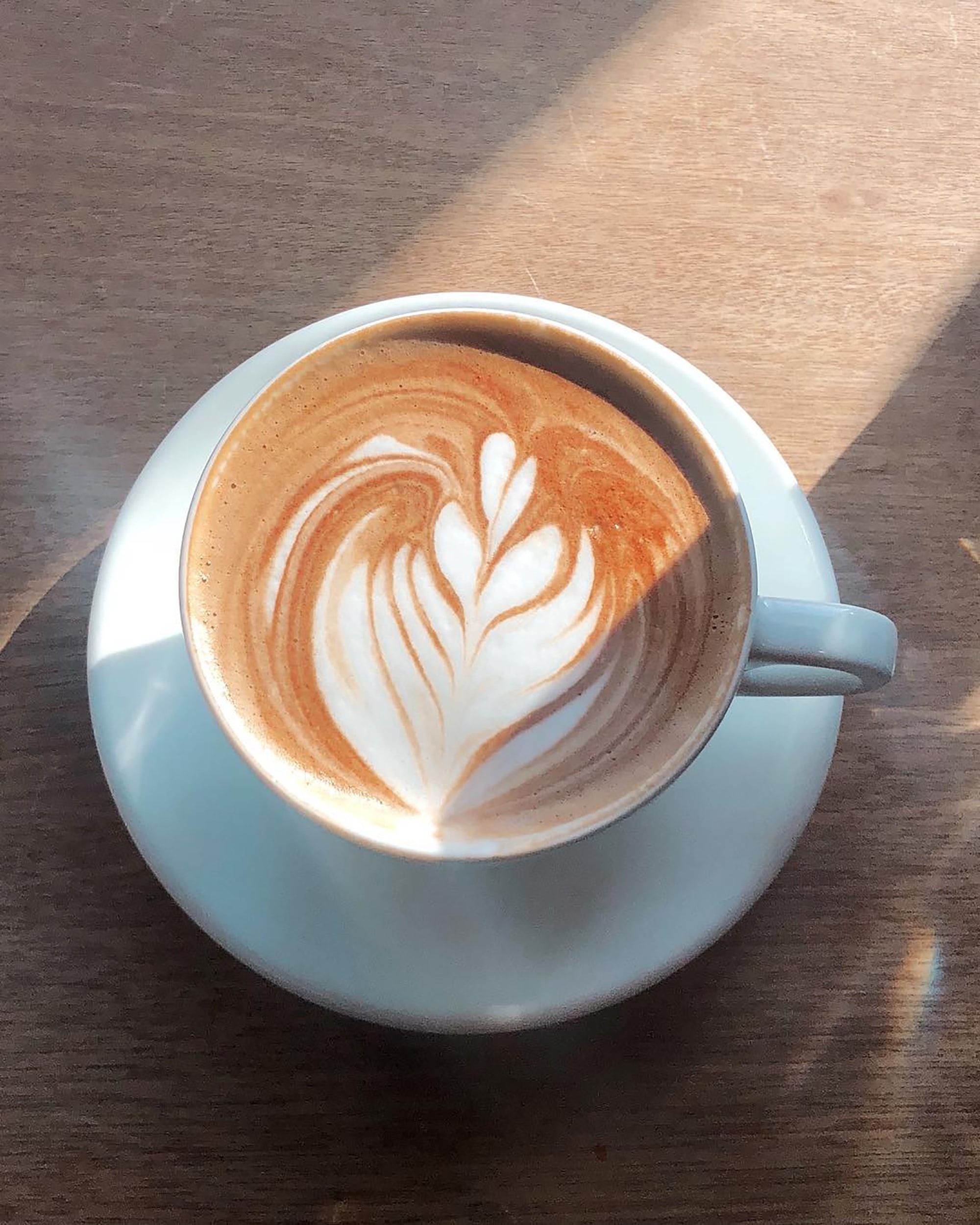 Taza de cafe color blanca con arte latte